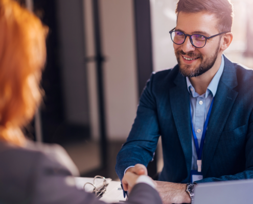 Ein Geschäftsmann schüttelt einer Bewerberin die Hand nach dem Bewerbungsgespräch