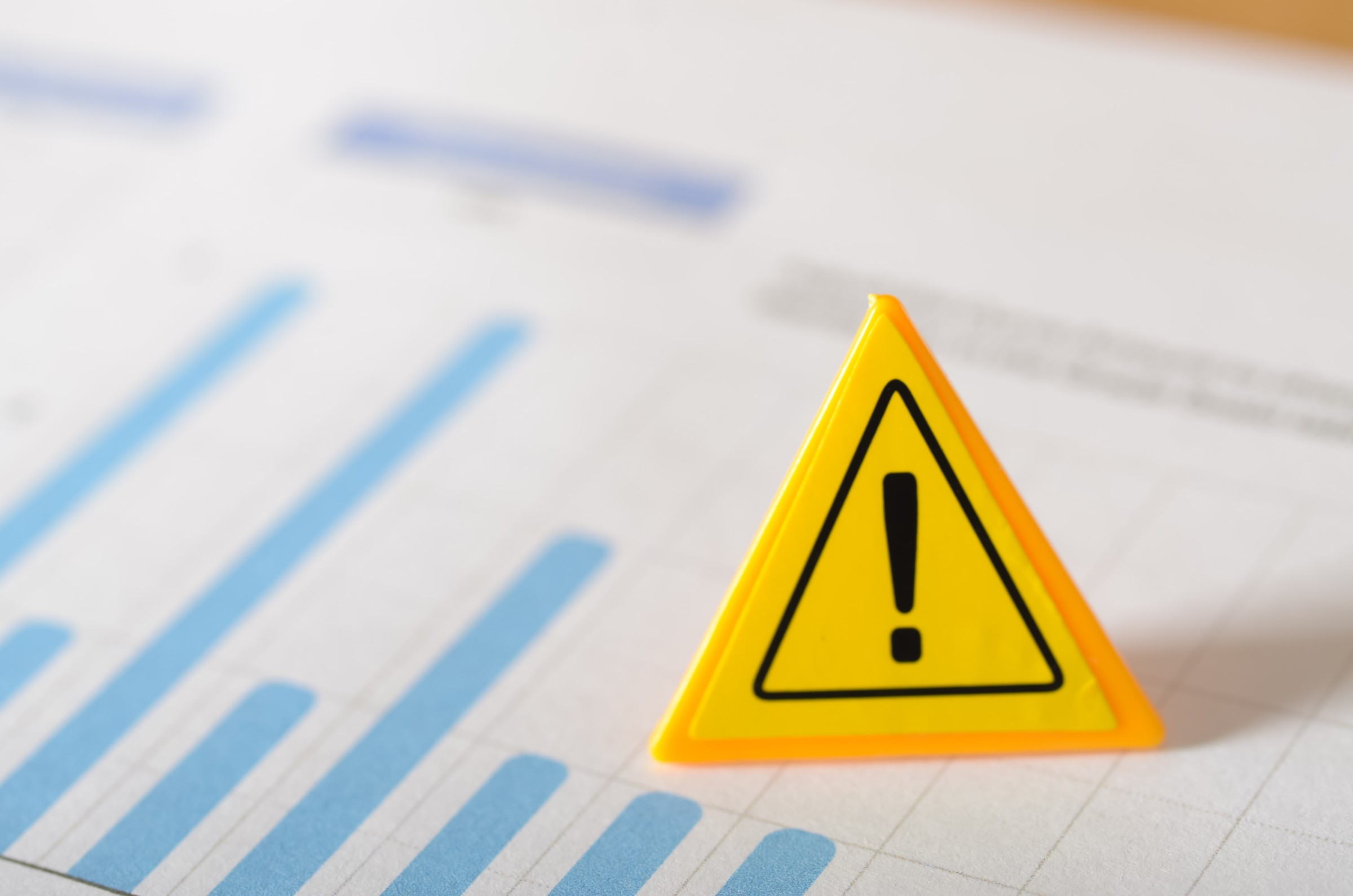 Miniatur-Warndreieck steht auf einem Dokument mit Diagrammen